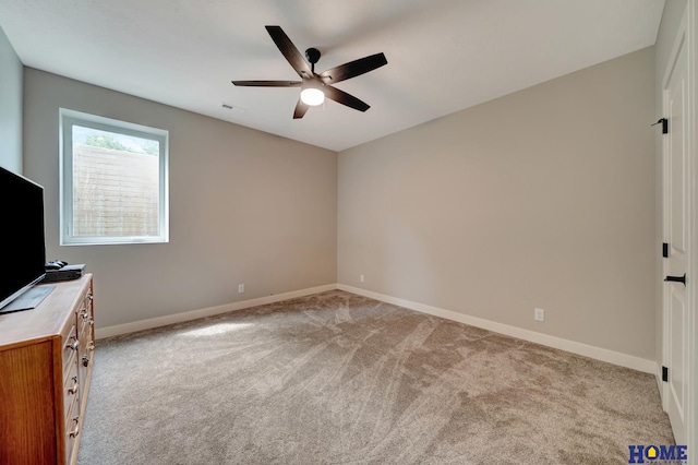 unfurnished bedroom featuring a ceiling fan, light colored carpet, visible vents, and baseboards