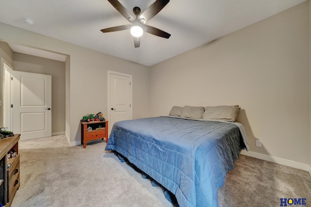 bedroom featuring baseboards, a ceiling fan, and light colored carpet