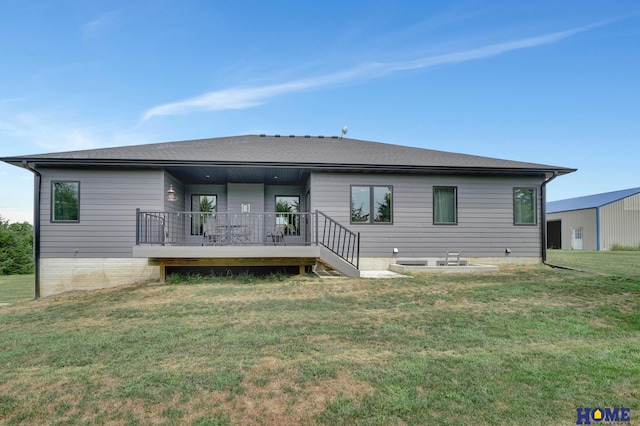 rear view of property with a deck and a yard