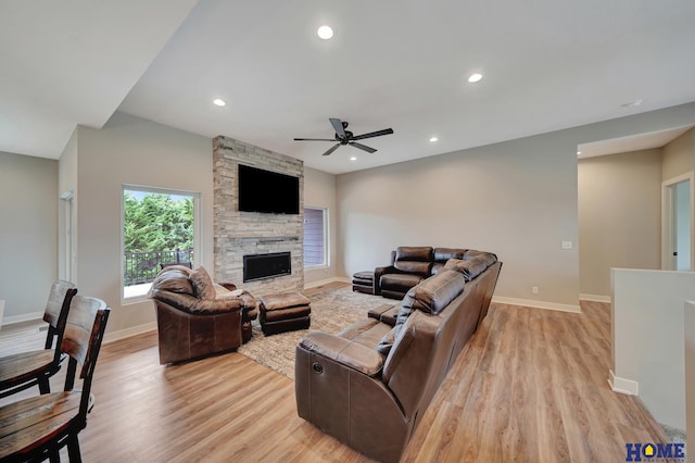 living room with light wood-type flooring, a fireplace, and recessed lighting