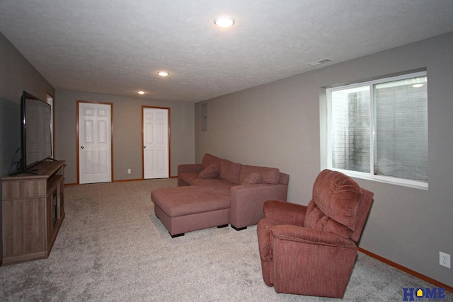 living room with a textured ceiling, recessed lighting, light carpet, visible vents, and baseboards