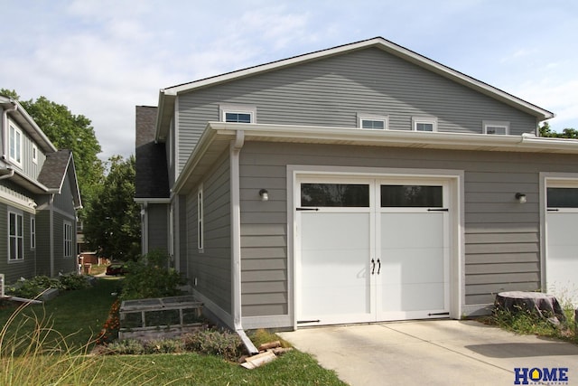 exterior space with a garage, a chimney, and concrete driveway