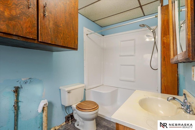 full bathroom with toilet, walk in shower, a drop ceiling, and vanity