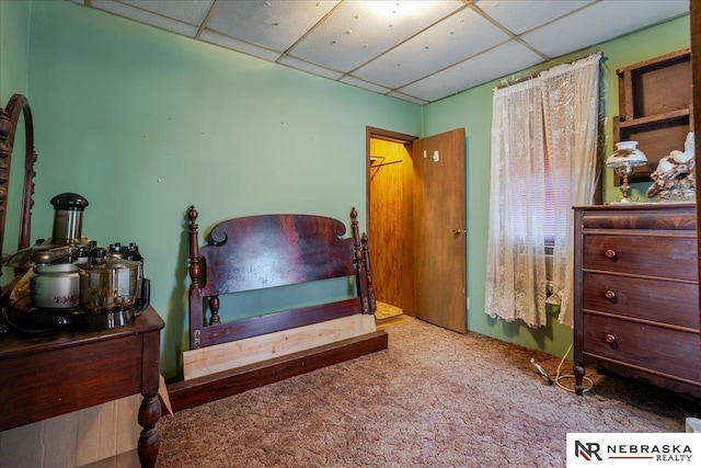 carpeted bedroom featuring a drop ceiling