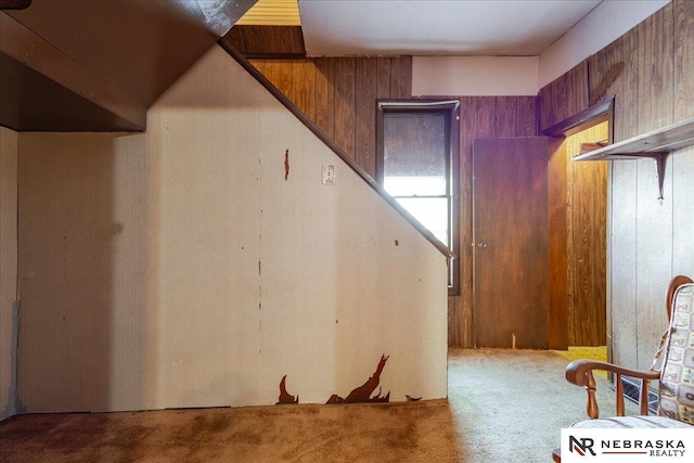 interior space featuring wooden walls and carpet flooring