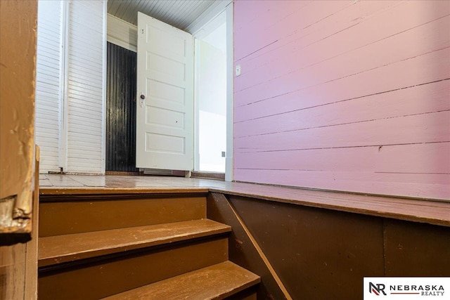 stairs featuring wooden walls