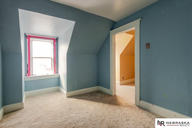 additional living space featuring baseboards, vaulted ceiling, and carpet flooring