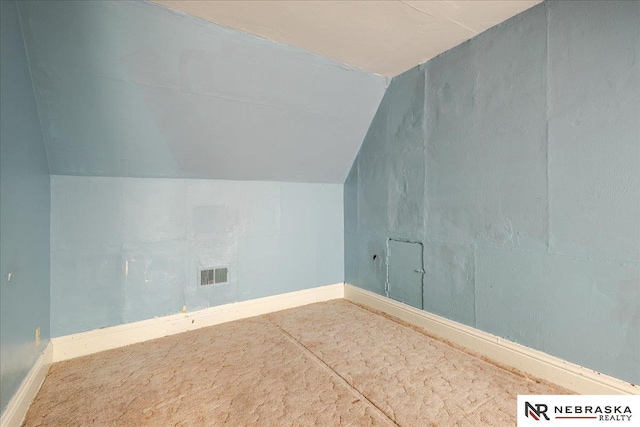 bonus room featuring lofted ceiling, visible vents, and baseboards