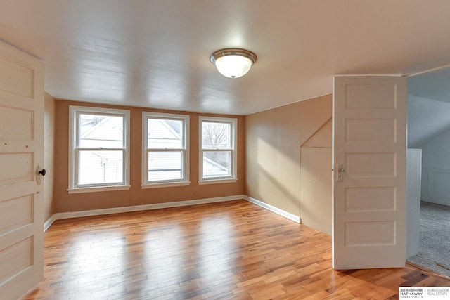 empty room with light wood-type flooring and baseboards