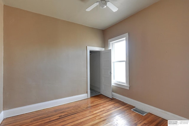 empty room featuring light wood-style flooring, visible vents, ceiling fan, and baseboards