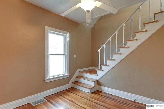 stairway with a ceiling fan, baseboards, visible vents, and wood finished floors