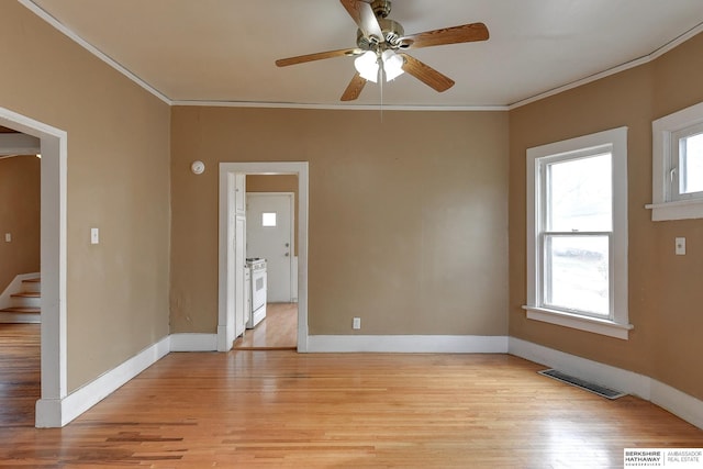 spare room with ornamental molding, light wood-type flooring, and visible vents