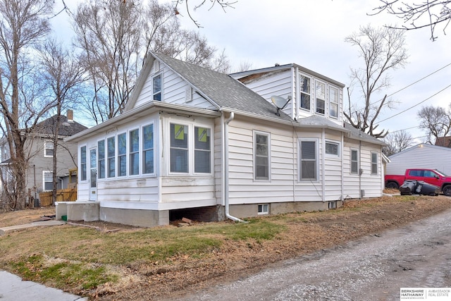 view of side of property with roof with shingles