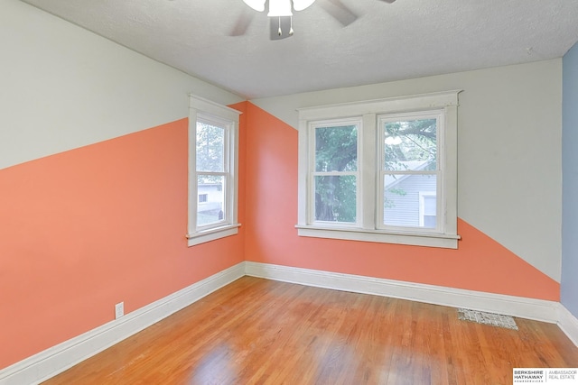 additional living space with visible vents, light wood finished floors, a wealth of natural light, and baseboards