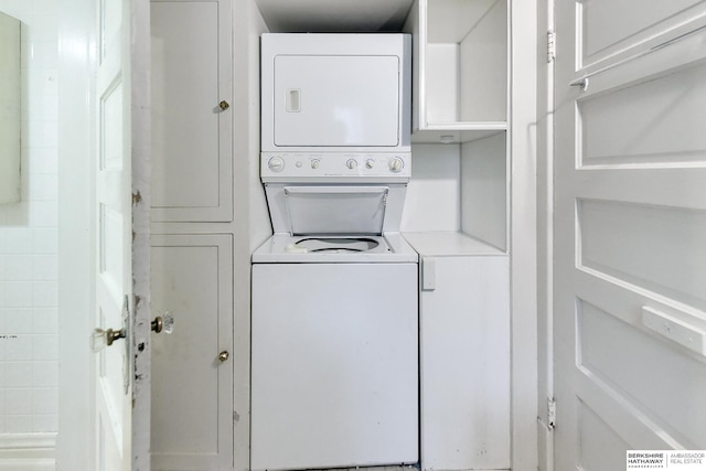 clothes washing area featuring stacked washer / drying machine