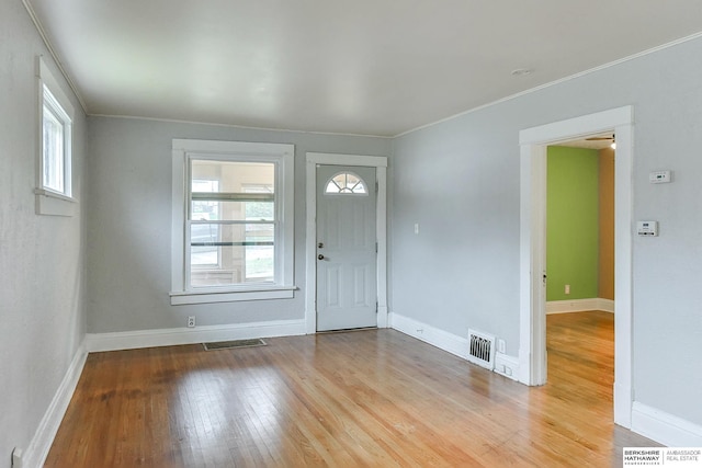 foyer with light wood-style floors, visible vents, and baseboards