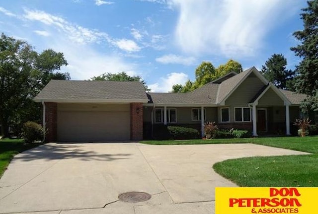 ranch-style house featuring concrete driveway, brick siding, a front lawn, and an attached garage