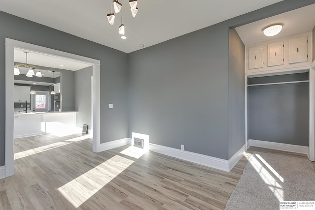 unfurnished dining area with baseboards, visible vents, and light wood-style floors