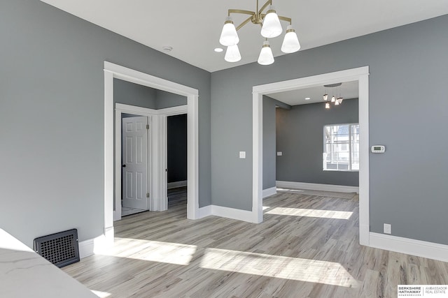 dining area featuring an inviting chandelier, light wood-style flooring, visible vents, and baseboards