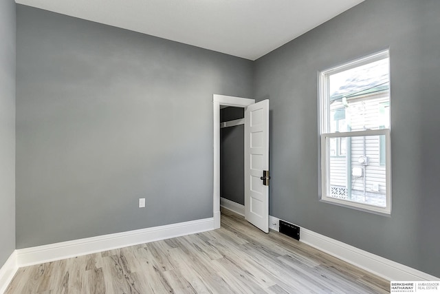 empty room with light wood-style flooring and baseboards