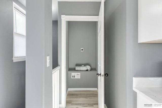 interior space featuring baseboards, plenty of natural light, and light wood finished floors