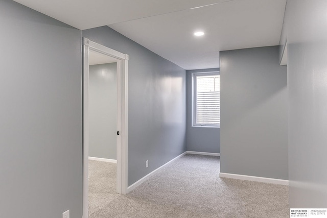 empty room featuring recessed lighting, light colored carpet, and baseboards