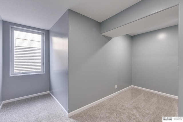 carpeted empty room featuring baseboards