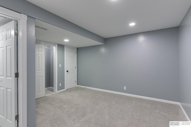 finished basement featuring light carpet, baseboards, and recessed lighting