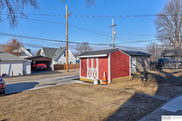 view of yard with an outbuilding, fence, driveway, a carport, and a storage unit