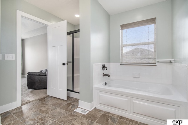 bathroom featuring a garden tub, baseboards, and a stall shower