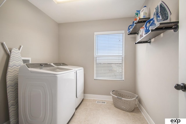 laundry room featuring laundry area, light tile patterned floors, baseboards, visible vents, and washer and dryer