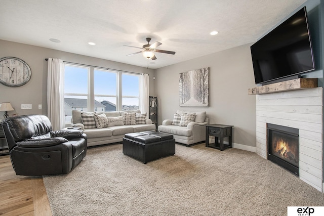 living room with a glass covered fireplace, ceiling fan, baseboards, and recessed lighting