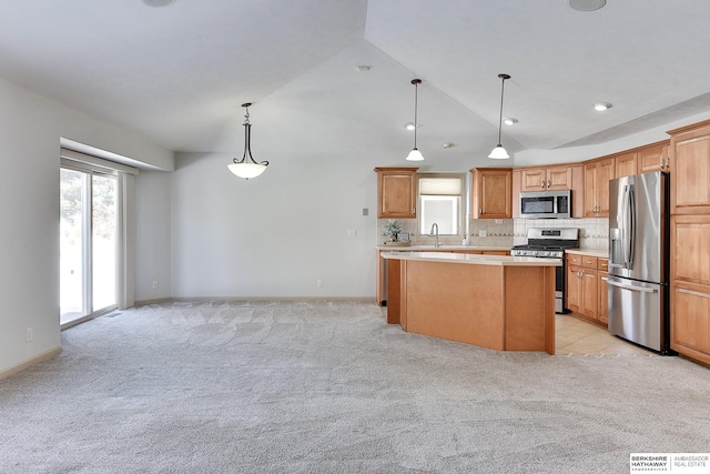 kitchen featuring pendant lighting, stainless steel appliances, light colored carpet, light countertops, and a kitchen island