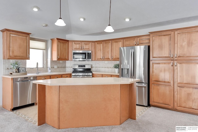 kitchen with light countertops, appliances with stainless steel finishes, a kitchen island, and pendant lighting