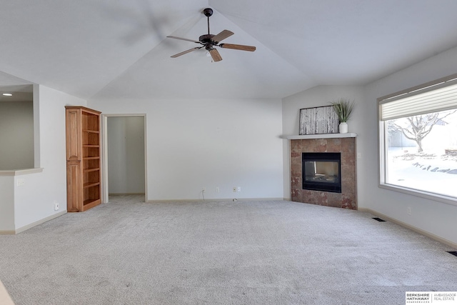 unfurnished living room featuring vaulted ceiling, light carpet, a fireplace, and visible vents