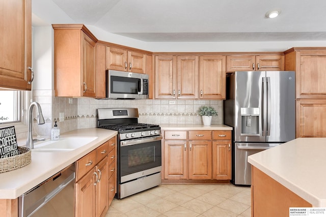 kitchen featuring a sink, stainless steel appliances, light countertops, and decorative backsplash