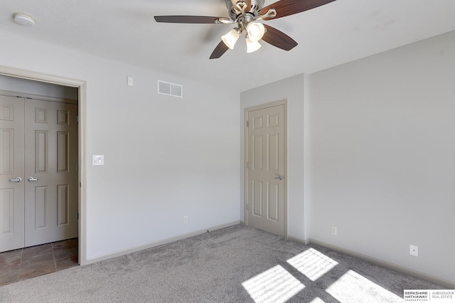 unfurnished bedroom featuring a ceiling fan, visible vents, light carpet, and baseboards