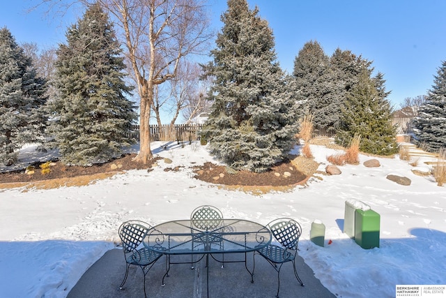 snow covered patio featuring fence