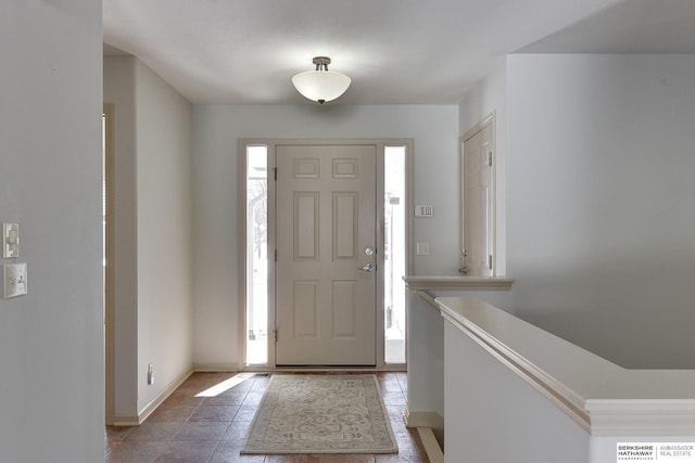 foyer entrance featuring light tile patterned floors and baseboards