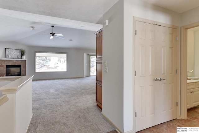 hallway featuring lofted ceiling with beams, a textured ceiling, light colored carpet, visible vents, and baseboards