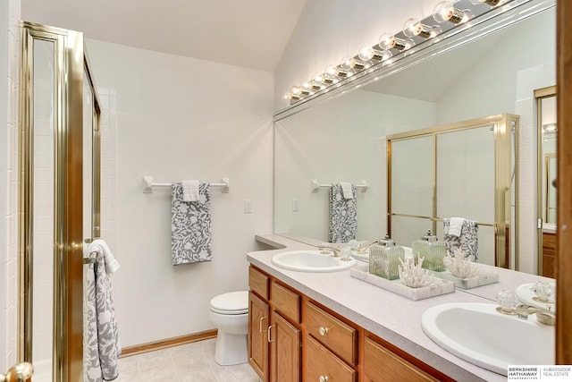 bathroom featuring toilet, a stall shower, double vanity, and a sink