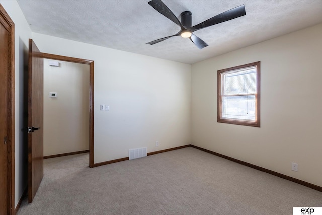 unfurnished room featuring baseboards, visible vents, and light colored carpet