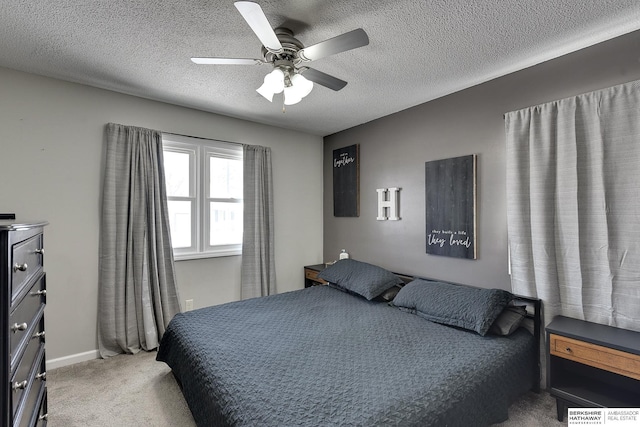 bedroom featuring ceiling fan, baseboards, a textured ceiling, and light colored carpet