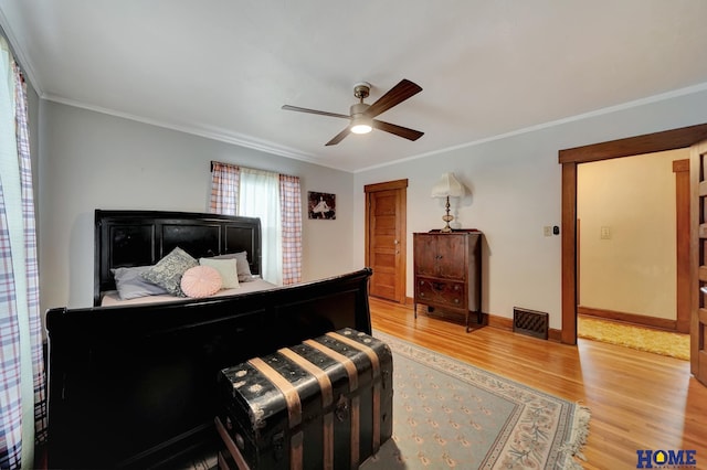 bedroom featuring a ceiling fan, light wood-style flooring, baseboards, and crown molding