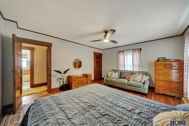 bedroom featuring crown molding, a closet, baseboards, and wood finished floors