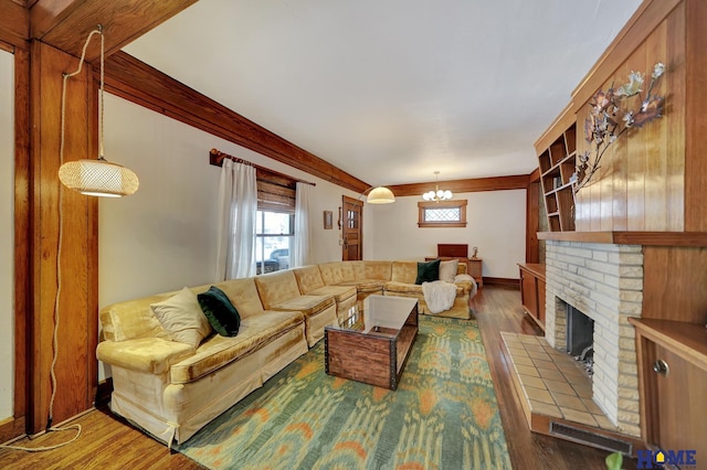 living room with a chandelier, a brick fireplace, wood finished floors, and visible vents