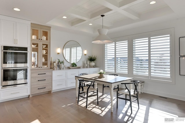 dining space with beamed ceiling, coffered ceiling, light wood-style flooring, and recessed lighting