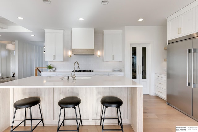 kitchen with white cabinetry, stainless steel built in refrigerator, and light countertops