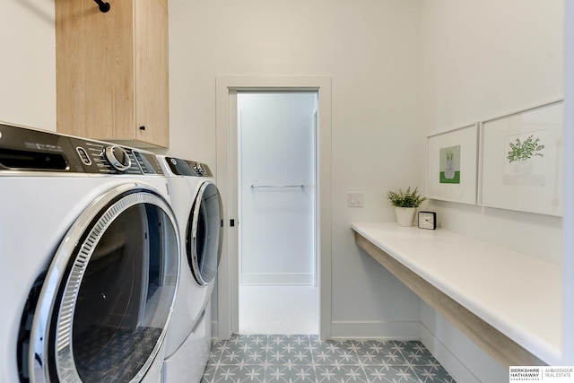 clothes washing area featuring light floors, washing machine and dryer, cabinet space, and baseboards