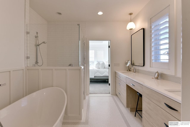 bathroom featuring plenty of natural light, a soaking tub, connected bathroom, and a decorative wall